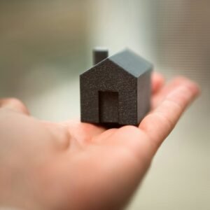 A person holding a small house in their hand